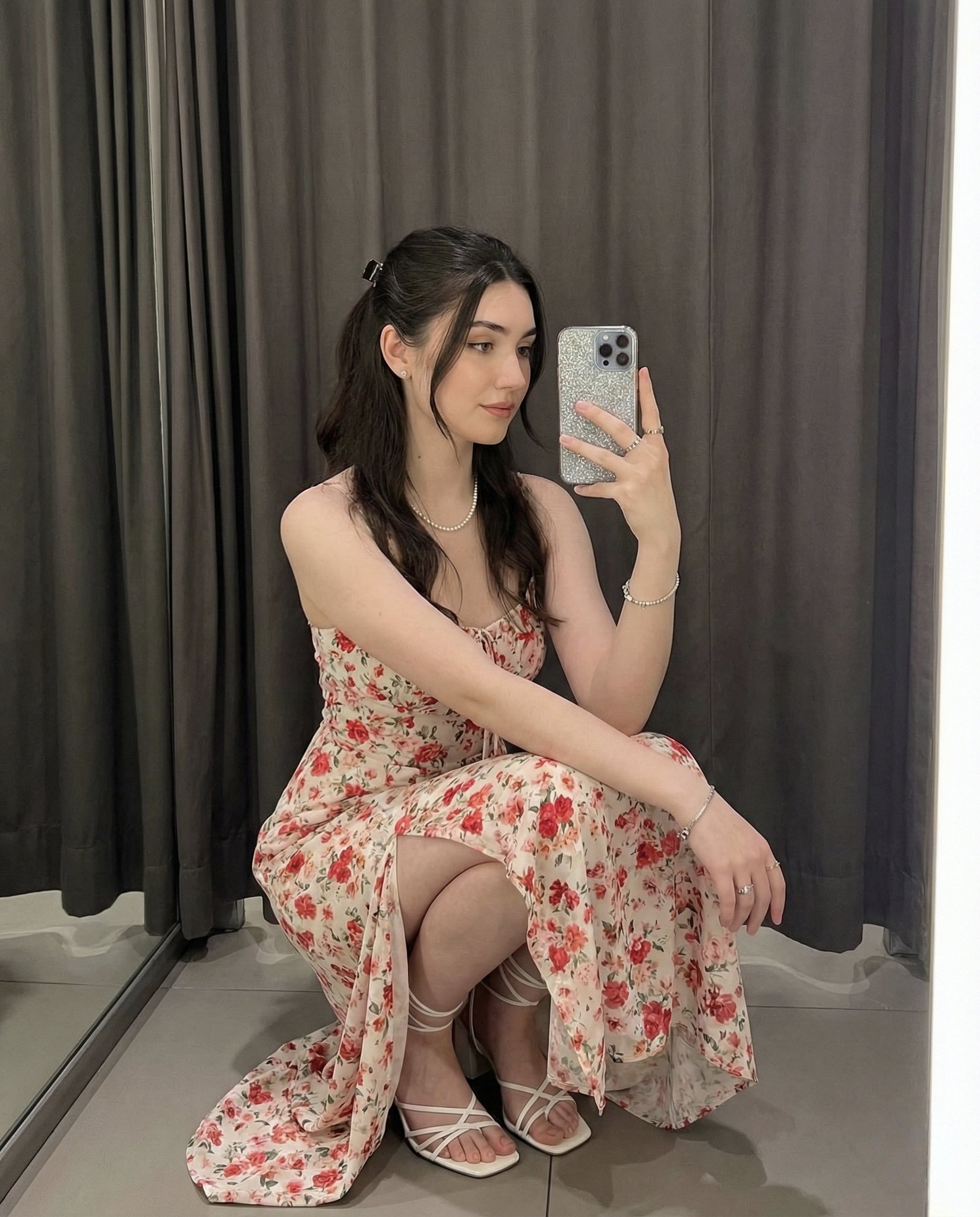 Young woman elegantly squatting for a selfie indoors